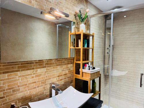 a bathroom with a sink and a glass shower at Comodidad cerca del centro Granada in Albolote