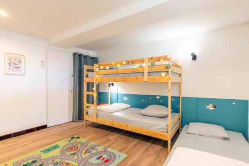 a bunk bed room with two beds and a rug at Maison Familliale Centre Fromentine in La Barre-de-Monts