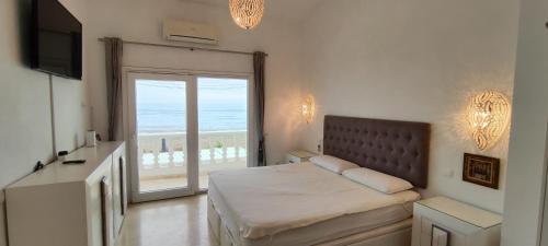 a bedroom with a bed with a view of the ocean at Beach House El Saladillo in Estepona