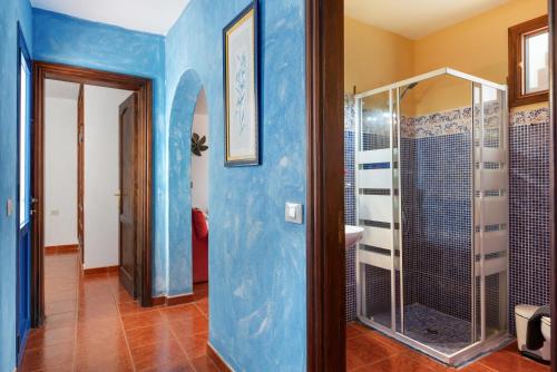 a bathroom with a shower and a blue wall at La Caletilla La Graciosa in Caleta de Sebo