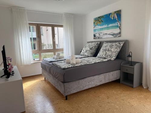 a bedroom with a bed in a room with windows at Casa Laguna in Oberteuringen
