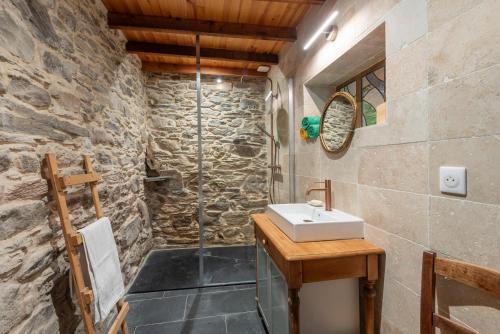 a bathroom with a sink and a stone wall at La Ketzerie à Adervielle in Adervielle