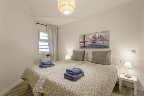 a bedroom with a bed with two towels on it at Apartamento Marte Centro in Los Cristianos