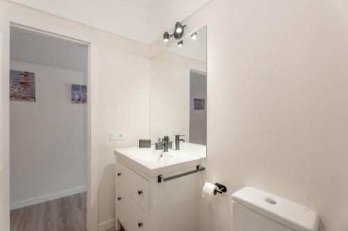 a white bathroom with a sink and a mirror at Apartamento Marte Centro in Los Cristianos