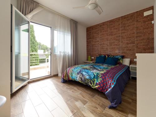 a bedroom with a bed and a brick wall at Naizan in L'Ametlla de Mar
