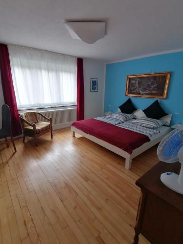 a bedroom with a bed and a chair and a window at Villa Bulla-ÿ in Bullay