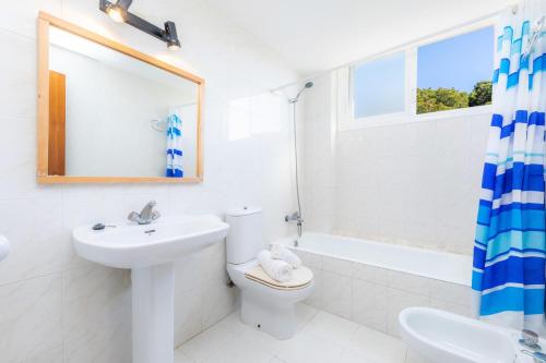 a bathroom with a toilet and a sink and a mirror at Apartamento Grillo in Cala Ratjada