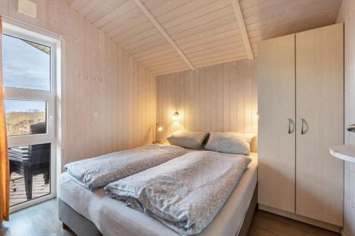 a bedroom with a large bed and a window at Skipper-Lodge Süd in Kosel