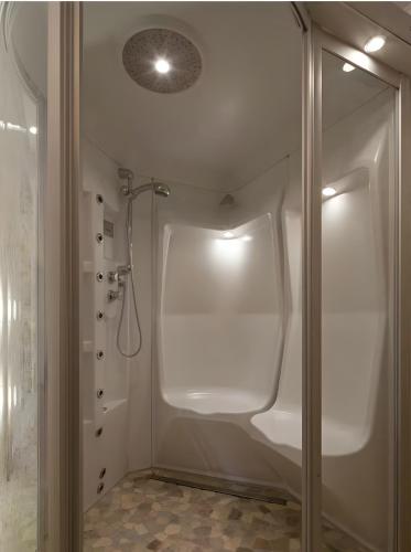 a white bathroom with a shower and a glass door at Ferienhaus Kuhweid in Drochtersen