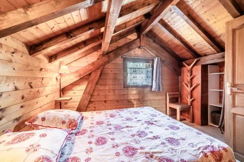 a bedroom with a bed in a wooden room at Chalet 6p Confort - L'ours blanc in Verchaix