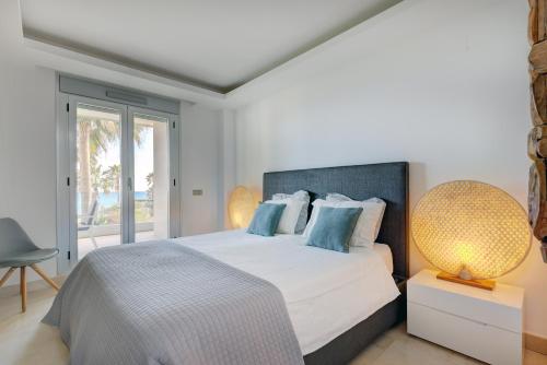 a bedroom with a large bed with blue pillows at Modern frontline beach - Estepona in Estepona
