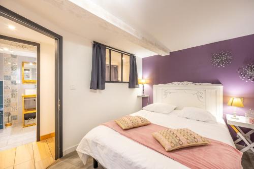 a bedroom with a white bed and purple walls at Les Glycines 1 in Les Épesses