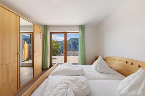 two beds in a room with a view of a balcony at Obertrisaierhof Wohnung 1 in Fie allo Sciliar