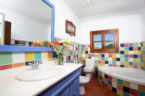 a bathroom with a sink and a tub and a toilet at Can Seguinot in Pollença
