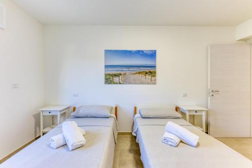 two beds in a room with a picture of the beach at Villa Bianca Appartament in Ugento