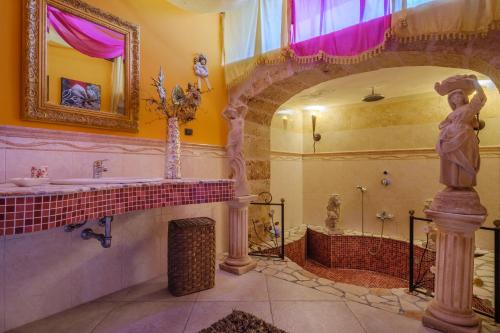 a bathroom with a statue of a woman next to a shower at Villa Chanel in Monteroni di Lecce