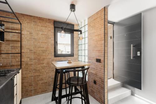 a small kitchen with a stool and a brick wall at La Mihilla in Málaga