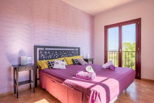 a bedroom with a large bed with purple sheets at Finca Son Puca in Petra