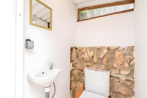 a bathroom with a toilet and a sink at Las Estrellas Cala Llombards in Cala Llombards