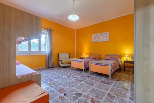 a room with three beds and a window at Appartamento Maria- Castelsardo in Castelsardo