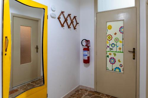 a mirror next to a door with a fire extinguisher at Appartamento Maria- Castelsardo in Castelsardo