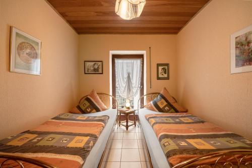 two beds in a room with a window at Ferienwohnung Eulennest 2 in Minheim