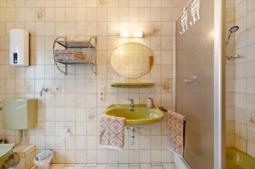 a bathroom with a sink and a toilet and a mirror at Ferienwohnung Eulennest 2 in Minheim