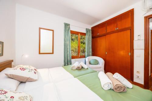 a bedroom with a large white bed and a chair at Es Puig de Ses Coves in Santa Eugenia