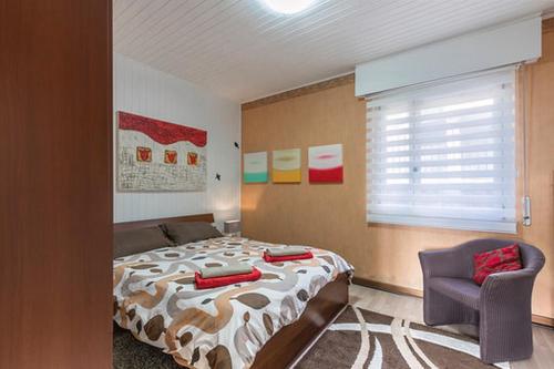 a bedroom with a bed and a chair and a window at Casa Heli 1 lake view in San Zeno di Montagna