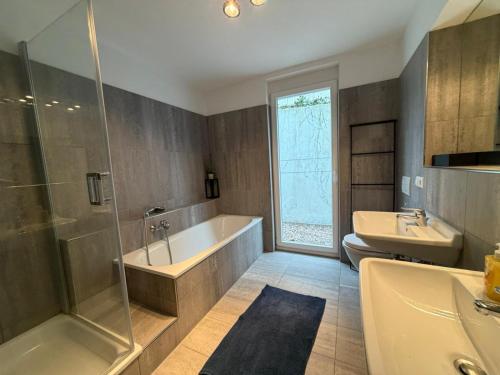 a bathroom with a tub and a shower and a sink at Ferienwohnung Steni in Wehr