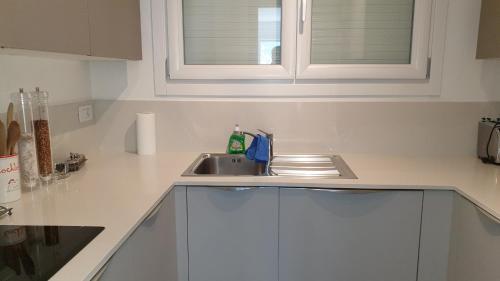 a kitchen counter with a sink and a window at Modern apartament in Porlezza