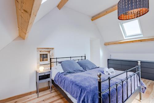 a bedroom with a bed with a blue bedspread at Gite La Mauratie -4 chambres in Jayac