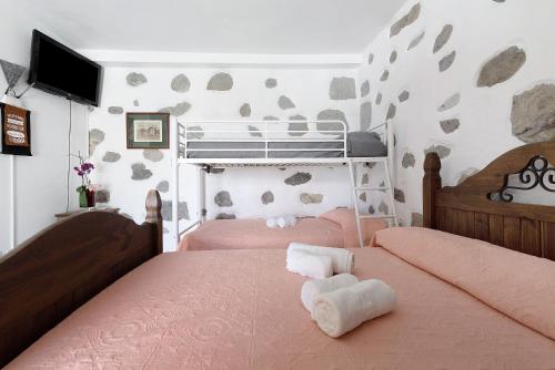 a bedroom with two beds with pink sheets at Vivienda Vacacional Risco Blanco in San Bartolomé