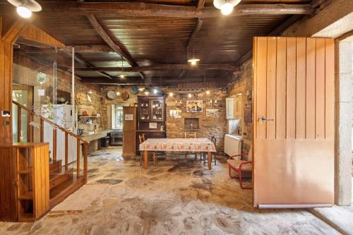 a dining room with a table and a stone wall at Casa Do Riacho - Douro in Armamar