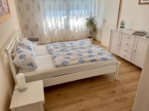 a bedroom with a bed with a blue and white comforter at Ferienappartement - Haus am See in Woltersdorf