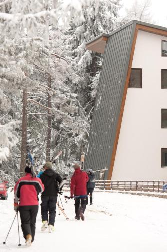 a group of people walking in the snow near a building at Euphoria Club Hotel in Borovets