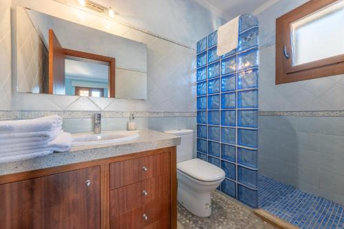 a bathroom with a sink and a toilet and a mirror at Caril in Binissalem