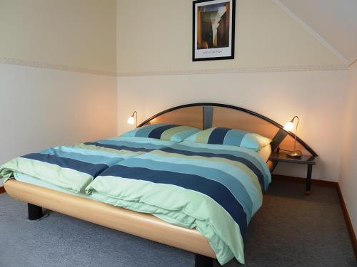 a bedroom with a bed with blue and white stripes at Angelas Ferienwohnung in Cuxhaven