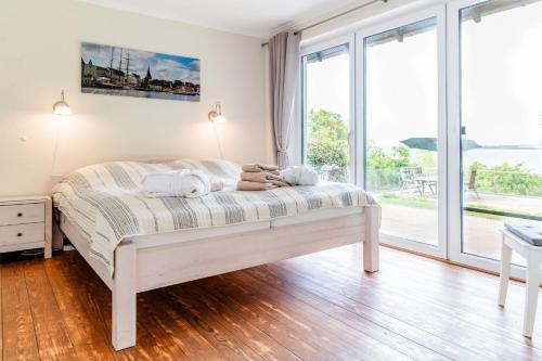 a bed with a person laying on it in a room with windows at Haus Seeblick in Langballig