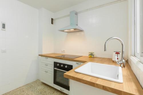 a kitchen with a sink and a stove at Moli Apartment Beach in Canet de Mar
