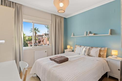 a bedroom with a large white bed with a window at Topacio A114 in Mijas Costa