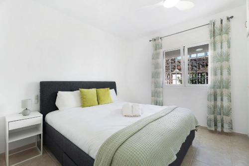 a white bedroom with a large bed and a window at House Carla Private Pool Heated in Puerto de Santiago