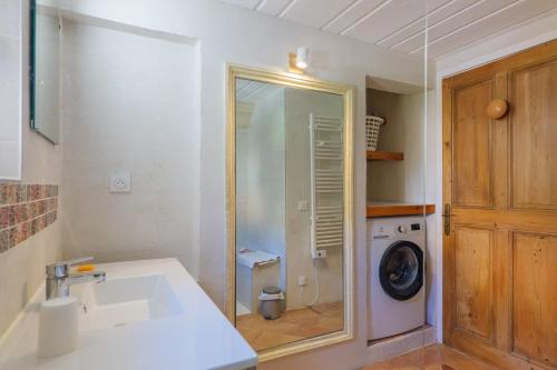 a bathroom with a sink and a washing machine at Le Barry in Tulette