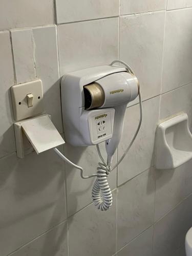 a phone on a wall next to a hair dryer at Traditional Rooms Elena in Astirákion