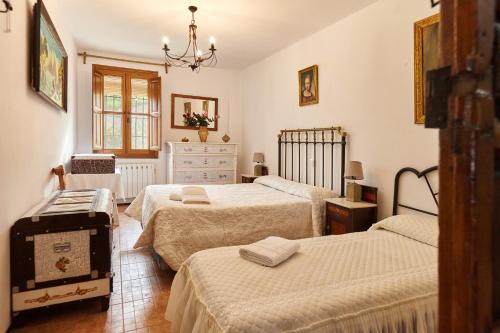 a bedroom with two beds and a dresser at Cortijo Rural Majolero 3 in Castillo de Locubín