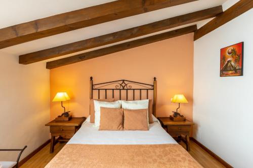 a bedroom with a large bed and two lamps at Casa el Arroyal in Rades de Abajo