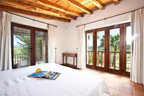 a bedroom with a bed and sliding glass doors at Villa Can Rafal Ibiza in Sant Josep de sa Talaia