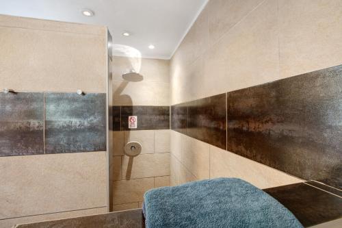 a bathroom with a shower with a blue stool at Ferienwohnung Sonnendeck in Laupheim