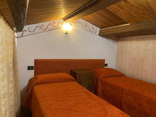 a bedroom with two beds and a light on the wall at Casa dell'uliveto in Albettone