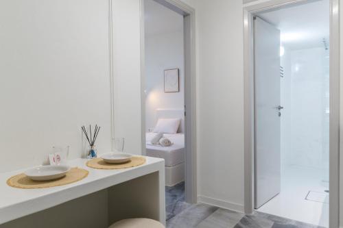 a white bathroom with a sink and a shower at A Tinian Room 2 in Tinos
